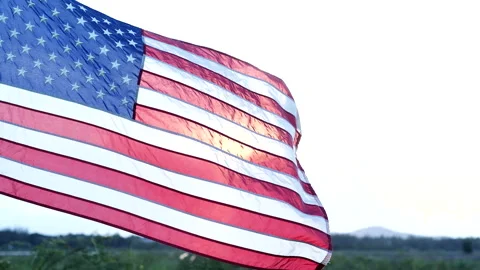 Close-up American flag waving over sunset in nature background Stock Footage 154954960