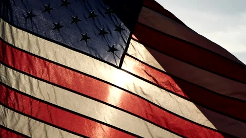 Close-up American flags waving over sunset or sunrise in nature background Video stock 154917250