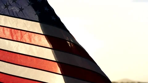 Close-up American flags waving over sunset or sunrise in nature background Video stock 154917273