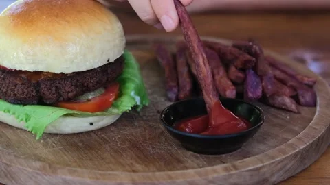 Close-up in an American restaurant, an appetizing burger lies on a wooden plate Stock Footage 199239662