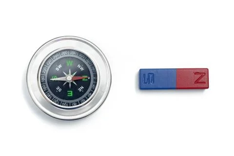 Close up analog compass and bar magnet over white background.  Stock Photos