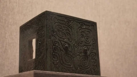 Close-up of Ancient Bronze Artifact with Intricate Carvings on Wooden Stand 스톡 동영상 340468095