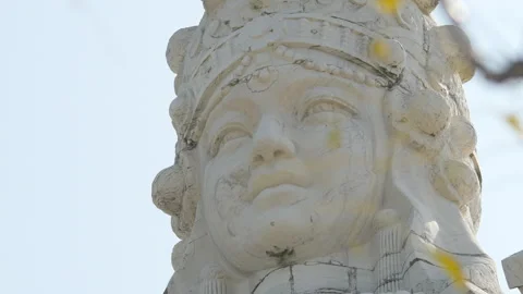 Close Up of Ancient Stone Buddha Statue Against Blue Sky Stock Footage 324559897