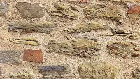Close-up of an ancient stone wall texture with rough masonry and sandy mortar Stock Footage 346654306