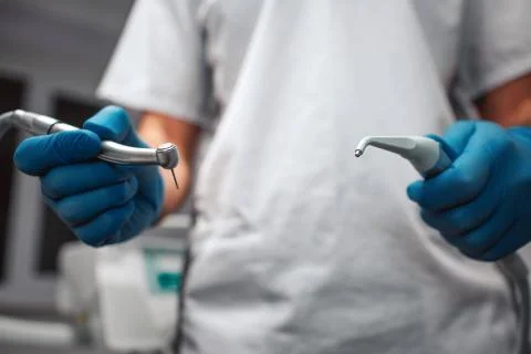 Close up and cut view of man's hands holding teeth equipment for treatment. He Stock Photos