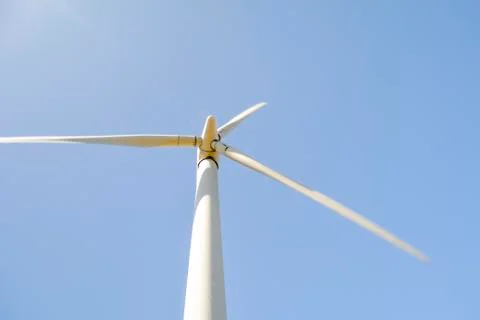 Close-up and low angle view of spinning blades of a wind turbine generating r Stock Photos