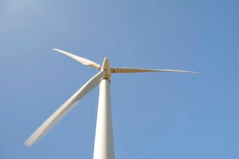 Close-up and low angle view of spinning blades of a wind turbine generating r Stock Photos