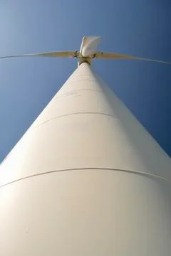 Close-up and low angle view of spinning blades of a wind turbine generating r Stock Photos