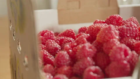 Close up and pan of freshly picked raspberries in carton Stock Footage 134120837
