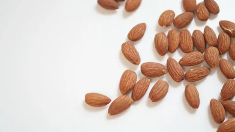 Close up and panning shot of roasted almonds on white background Stock Footage 104234840