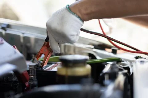 Close up and Selective focus of car mechanic holding battery electricity cabl Foto stock