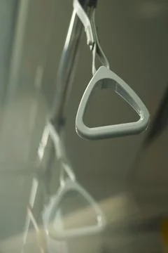 Close up and selective focus of grey triangle handle bar in the train. Photos