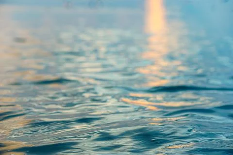 Close-up and selective focus view of sunlight reflection in water at sunset Stock Photos