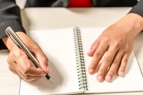 Close-up and selective focus of a woman's handwriting with a notebook place.. Stock Photos