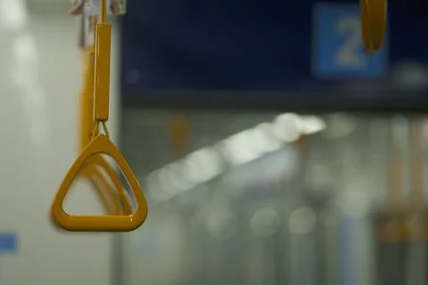 Close up and selective focus of yellow triangle handle bar in the train. Photos