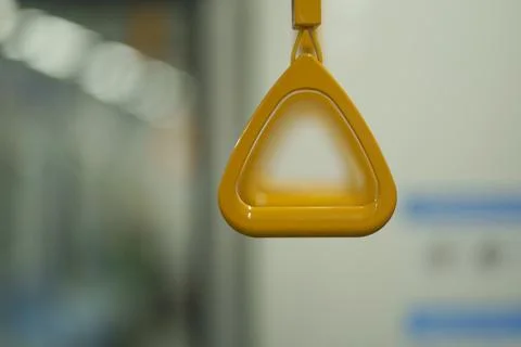 Close up and selective focus of yellow triangle handle bar in the train. Photos