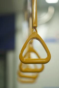 Close up and selective focus of yellow triangle handle bar in the train. Photos