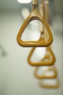 Close up and selective focus of yellow triangle handle bar in the train. Photos