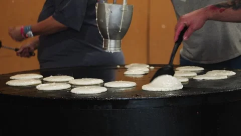 Close up and zoom out on multiple pancakes being cooked on large griddle Stock Footage 240121585