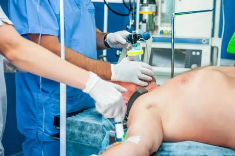 Close up anesthesiologist inserts the syringe making anesthesia to a patient Stock Photos