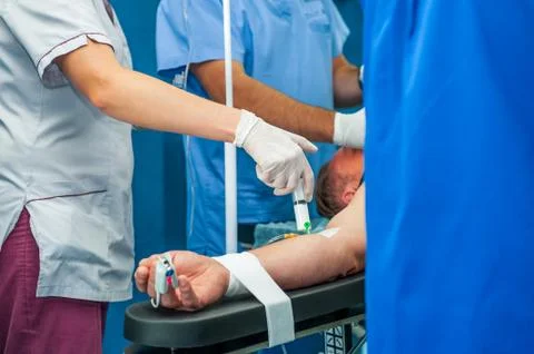 Close up anesthesiologist inserts the syringe making anesthesia to a patient Stock Photos