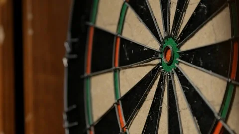 Close up angle darts sticking into dart board Stock Footage
