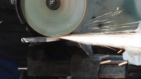 Close-up of an angle grinder cutting metal by worker in a factory, slow motion Stockbeeldmateriaal 143492826