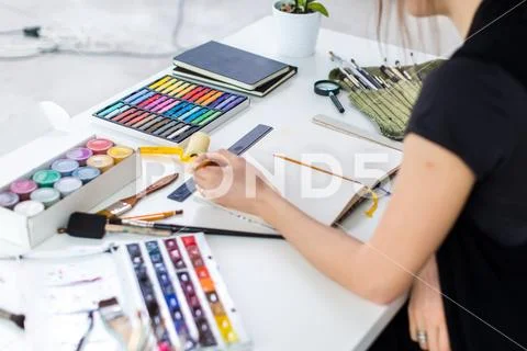 Close-up angle view of a female painter drawing draft at sketchbook using pencil Stock Photos