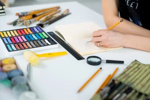Close-up angle view of a female painter drawing draft at sketchbook using pencil Stock Photos