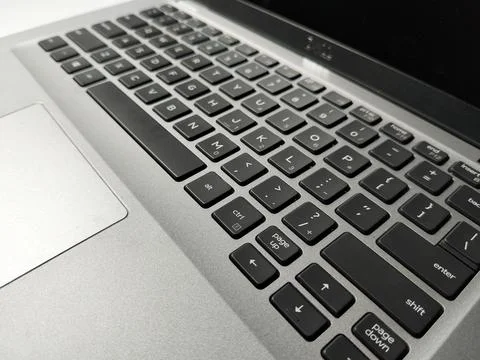 Close up angled view of a modern silver laptop keyboard, representing digital bu Foto stock