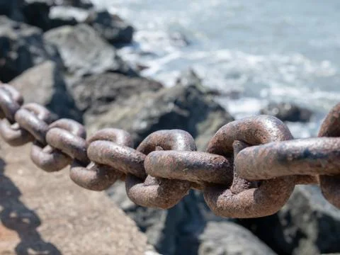 Close angled view of a thick rusty chain used as a barrier to th Stock Photos