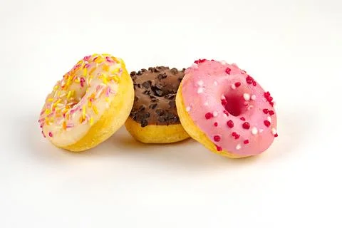 Close-up, angled view of a trio of glazed donuts one with multicolored sprink Stock Photos