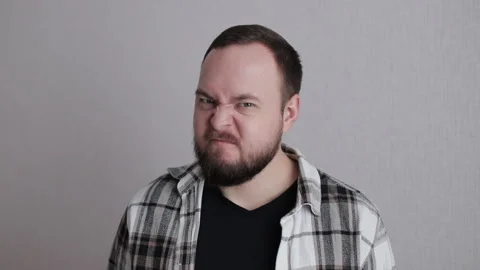 Close-up of angry young bearded man face frowning Stock Footage 300859378