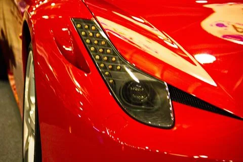 Close-up of angular black headlight with LED daytime running lights on glossy Stock Photos