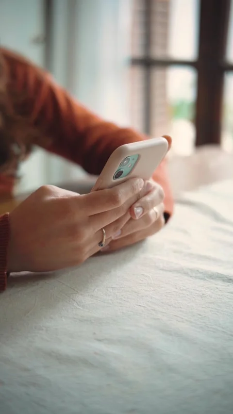 Close-up of an anonymous woman using her smartphone at home, highlighting mobile Stock Footage 346321826