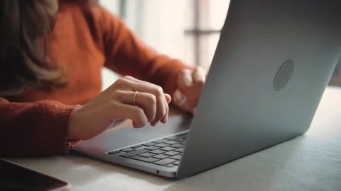 Close-up of an anonymous woman’s hands typing on a laptop, highlighting digital  Stock Footage 346321585