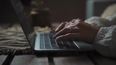 Close-up of an anonymous woman’s hands typing on a laptop at night at home. Remo Stock Footage 346323566