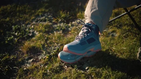 Close-up of an anonymous woman's trekking boots while she sits in a park, repres Stock Footage 346655116