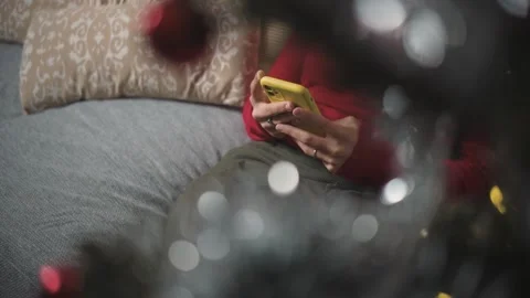 Close-up of anonymous young female hands using a smartphone during Christmas, hi Stock Footage 346004433