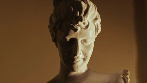 Close-up of an antique face sculpture in dynamic light Stock Footage 312077773