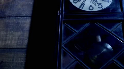 Close up of antique pendulum clock on wooden wall at night Stock Footage 130724135