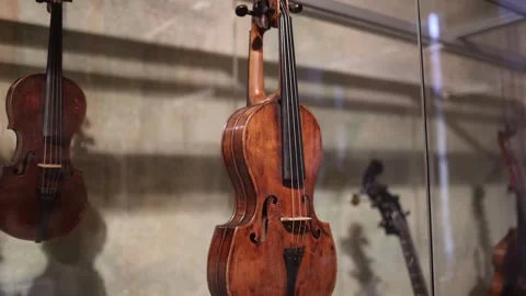 A close-up of an antique violin displayed in a museum, showcasing its rich woode Stock Footage 293565267