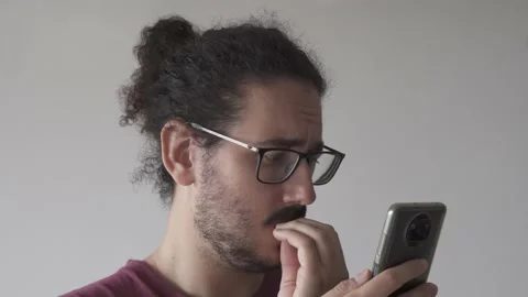 Close up of anxious man looking at smartphone and biting his nails Stock Footage 161552229