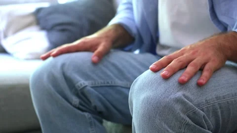 Close-up of an anxious man's hands tapping his fingers nervously on his jeans Stock Footage 344781717