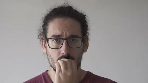 Close up of anxious young man biting his nails and looking at the camera Stock Footage 161552162