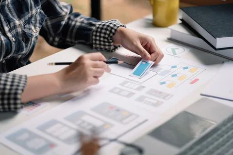 Close up App developer Ux Ui designing with paper model on mobile application Stock Photos