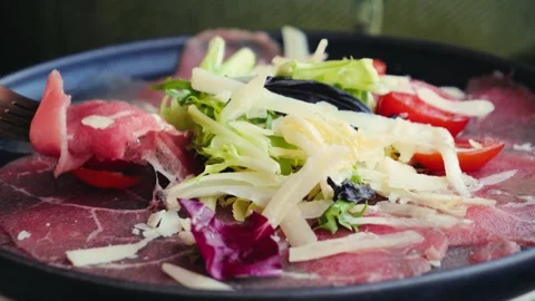 Close-up of appetizing carpaccio with arugula and parmesan sprinkled with Stock Footage 310562072