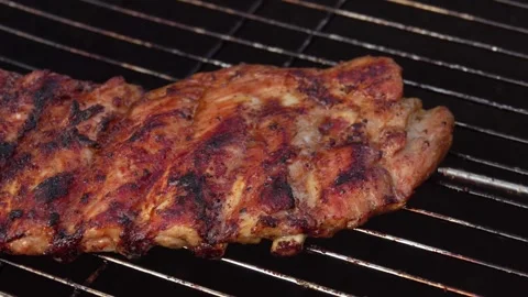 Close-up of the appetizing crunchy ribs rotated on the grill Video stock 153109837