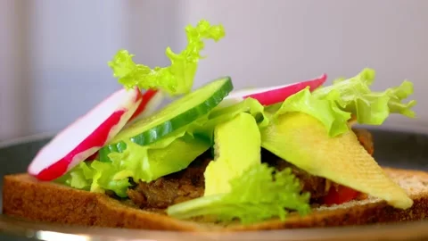 Close-up of an appetizing sandwich with a vegan cutlet and fresh vegetables. On Stock Footage 169619782