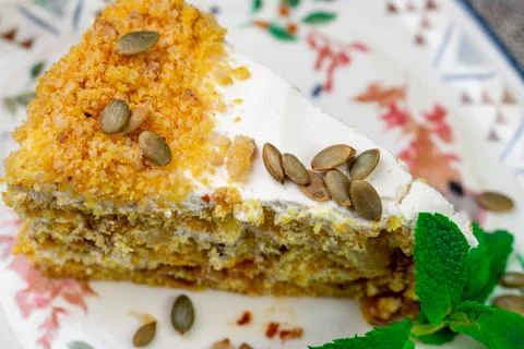 Close-up of appetizing slice of homemade pumpkin cake with sour cream and Stock Photos